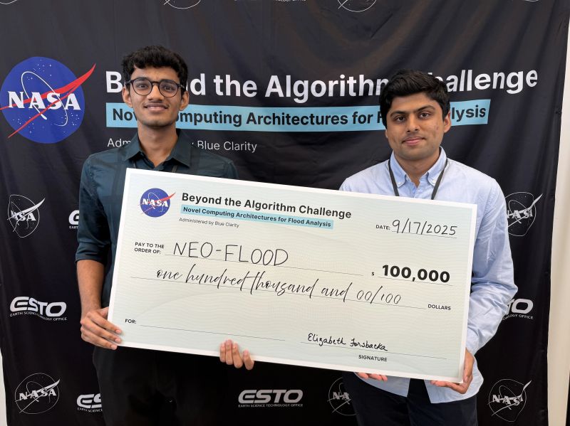 Two NEO-FLOOD team members holding the $100,000 winner's check at the NASA Beyond the Algorithm Challenge