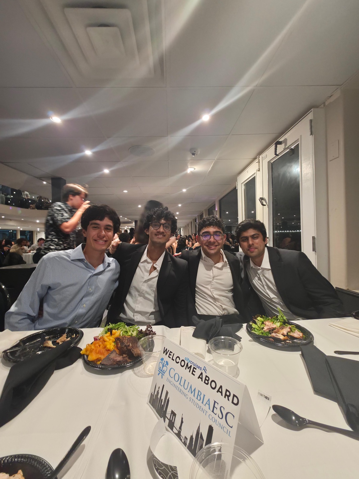 Four friends at a formal dinner on a boat cruise