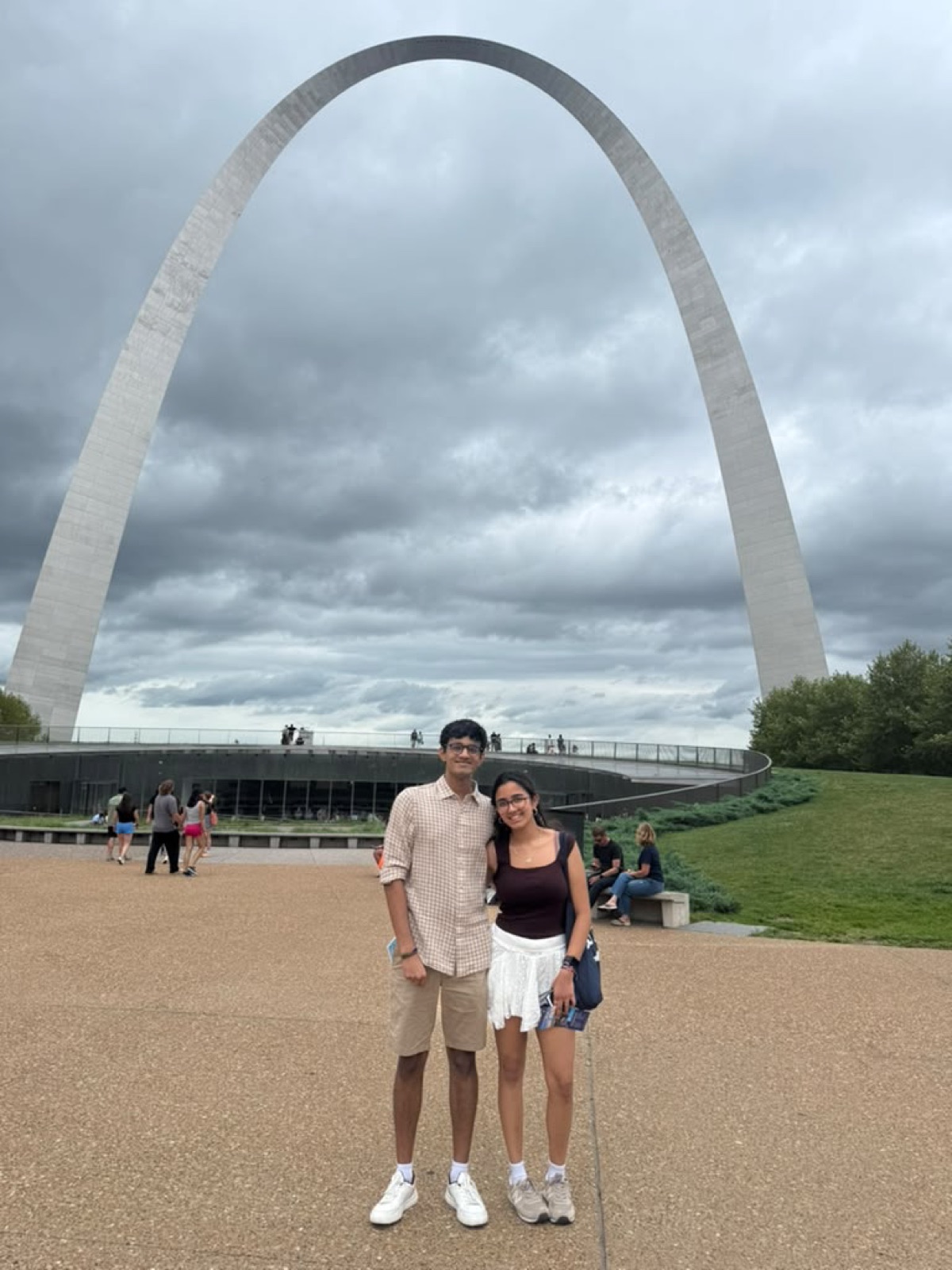 Two people in front of the Gateway Arch in St. Louis